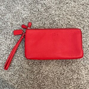 Red Coach wristlet bag with two zipper compartments.